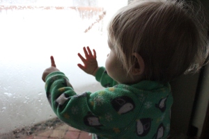 Writing her name on a frosted window pane.